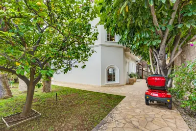 Villa entrance through a lush citrus garden